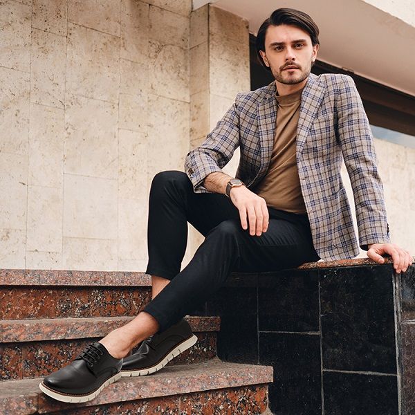 Man i rutig kavaj och svarta herrskor i en smart casual stil.